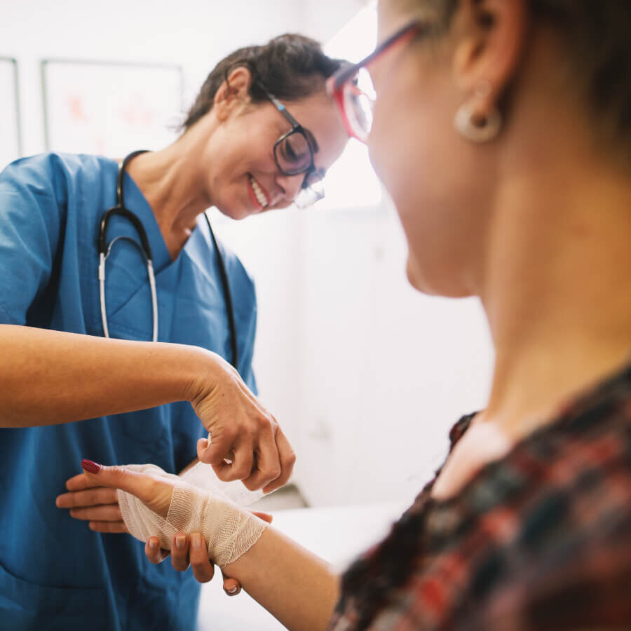 A nurse wrapping a patient's hand